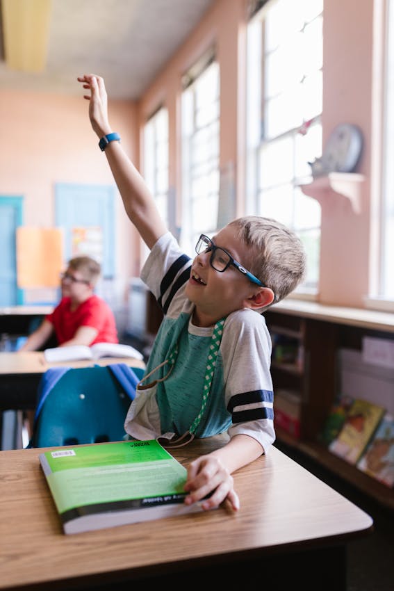 A child wearing glasses looking at a tablet screen up close